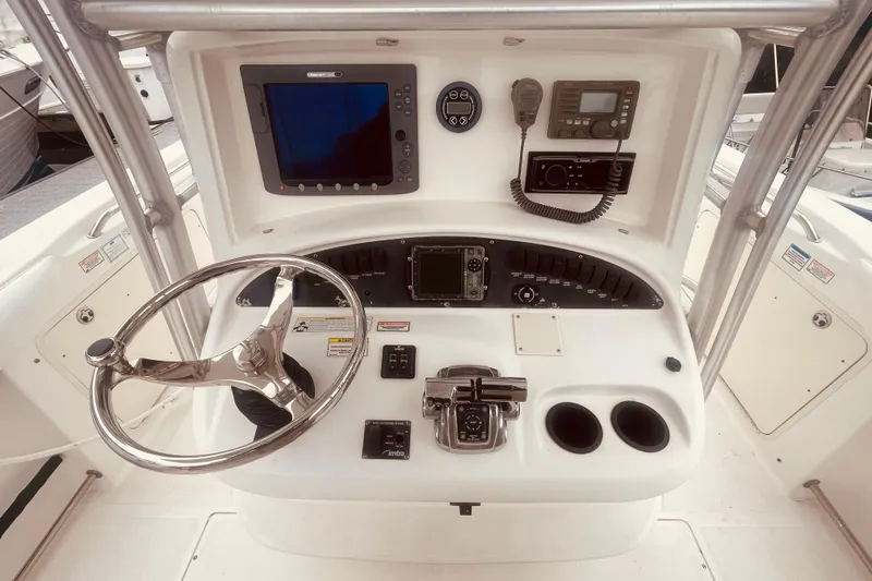 Slide: The Image of 2006 Boston Whaler 320 Outrage docked, showcasing spacious deck and seating area. - 11