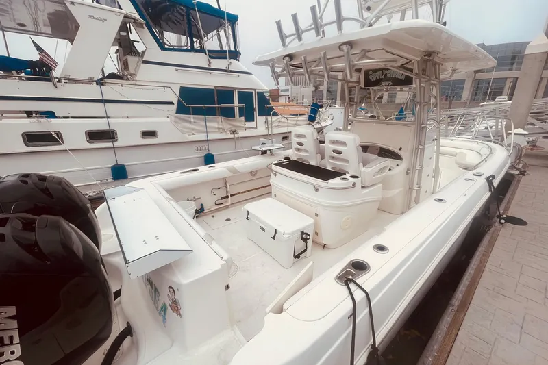 Slide: The Image of 2006 Boston Whaler 320 Outrage docked near palm trees and waterfront. - 2