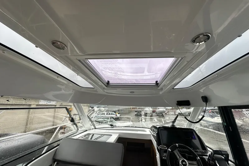 Slide: The Image of Interior view of 2023 Beneteau Antares 9 boat cockpit with sunroof and steering wheel. - 11