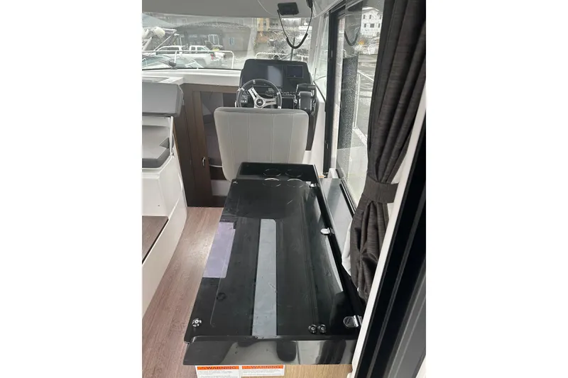 Slide: The Image of Interior view of 2023 Beneteau Antares 9, featuring helm and seating area. - 13