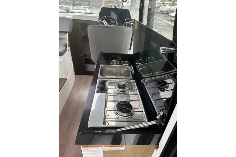 Slide: The Image of 2023 Beneteau Antares 9 interior kitchen with stove and sink. - 14