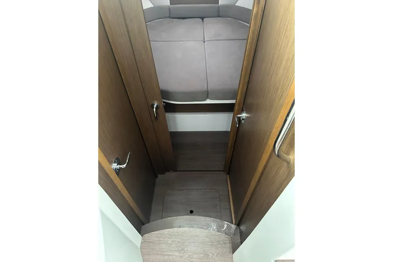 Slide: The Image of 2023 Beneteau Antares 9 cabin interior with wooden doors and cozy bed. - 16