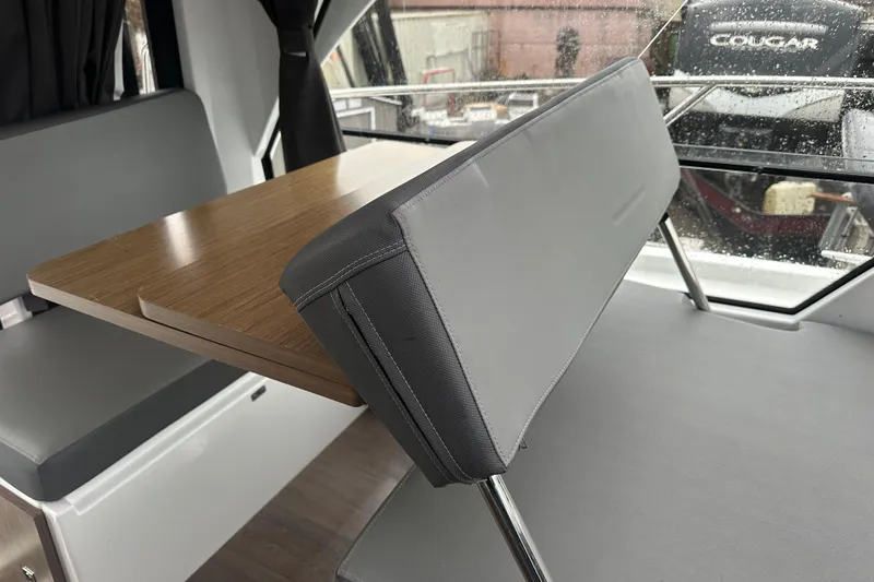 Slide: The Image of Interior of 2023 Beneteau Antares 9, featuring a sleek dining area with wooden table. - 18