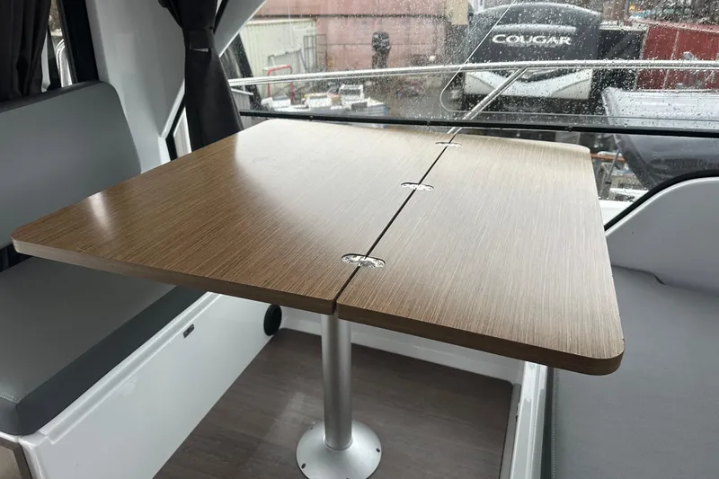 Slide: The Image of Interior of 2023 Beneteau Antares 9 with wooden table and seating area. - 20