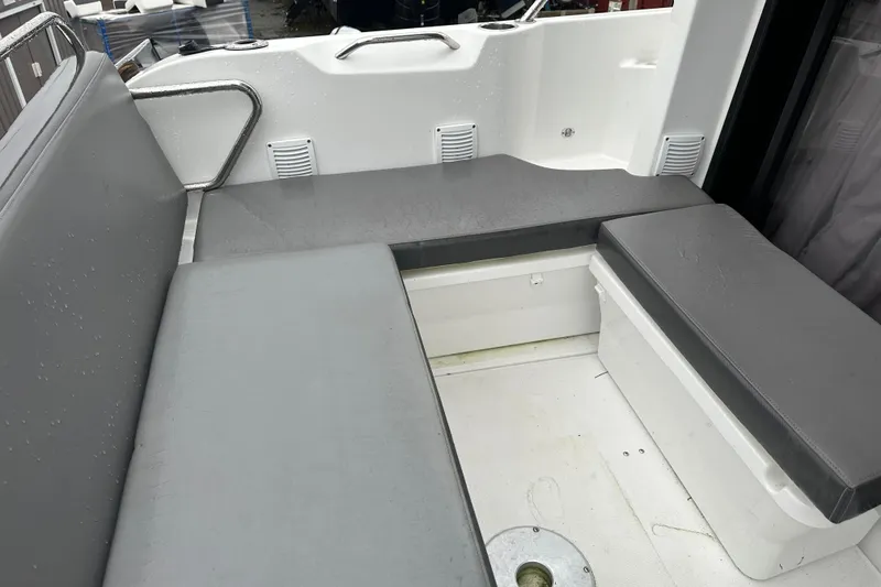 Slide: The Image of Interior seating area of a 2023 Beneteau Antares 9 boat, featuring gray cushions. - 29