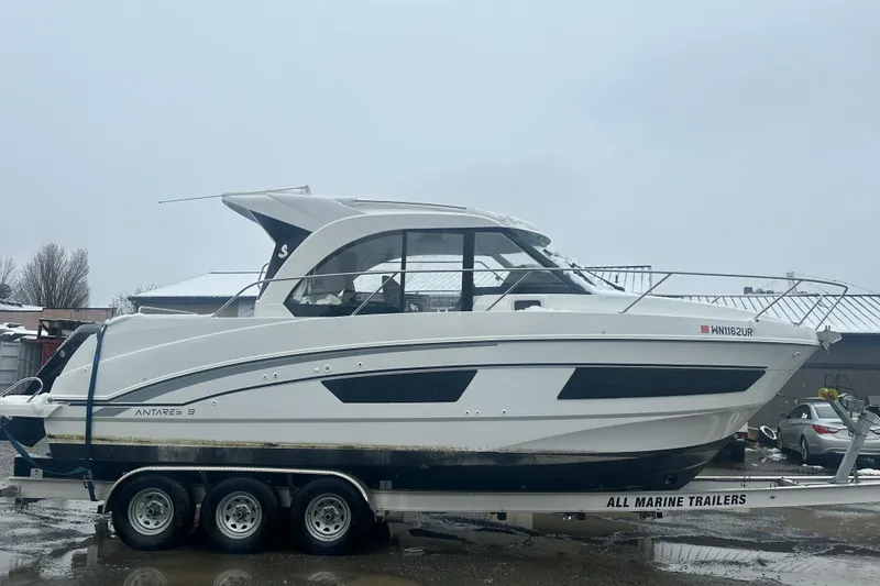 Slide: The Image of 2023 Beneteau Antares 9 boat on trailer, side view, in a snowy outdoor setting. - 4