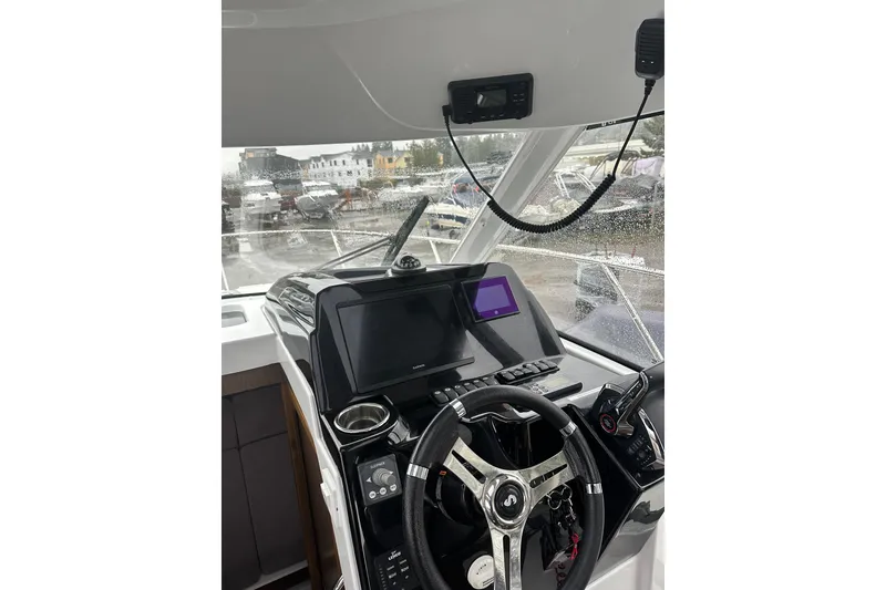 Slide: The Image of 2023 Beneteau Antares 9 helm with modern navigation equipment and steering wheel. - 7