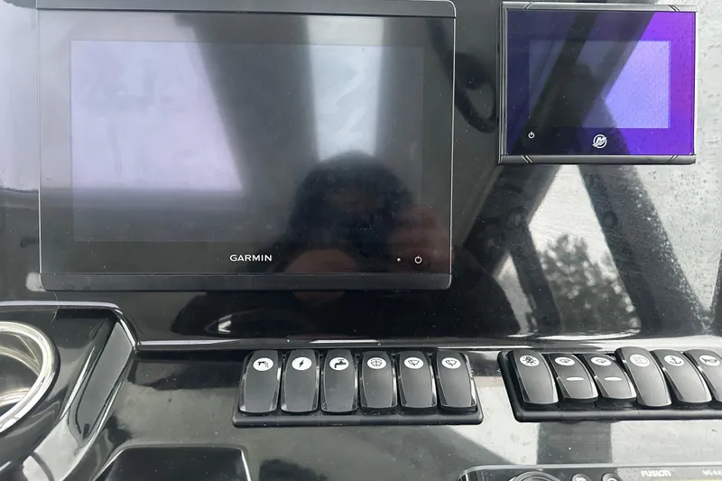Slide: The Image of Control panel of a 2023 Beneteau Antares 9 with Garmin display and switches. - 9