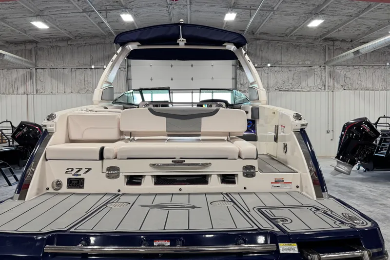 Slide: The Image of 2020 Chaparral 287 SSX boat in a showroom, showcasing rear seating and deck. - 5