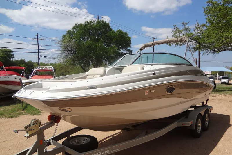 Slide: The Image of 2013 Crownline Eclipse E4 boat on trailer, parked outdoors under a clear sky. - 1