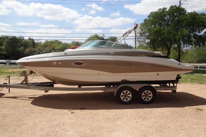 Slide: The Image of 2013 Crownline Eclipse E4 boat on trailer, parked outdoors under a sunny sky. - 2
