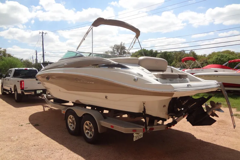 Slide: The Image of 2013 Crownline Eclipse E4 boat on trailer, parked outdoors under a sunny sky. - 3