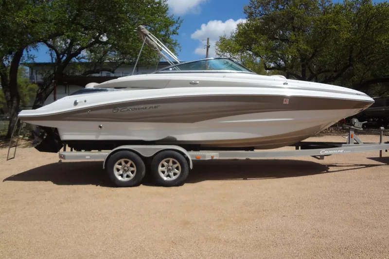 Slide: The Image of 2013 Crownline Eclipse E4 boat on trailer, parked outdoors under trees. - 6