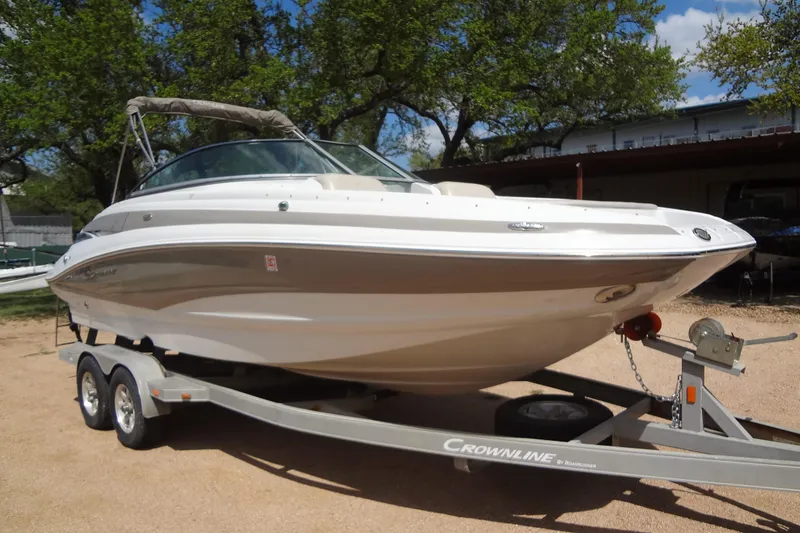 Slide: The Image of 2013 Crownline Eclipse E4 boat on trailer, parked outdoors under trees. - 7