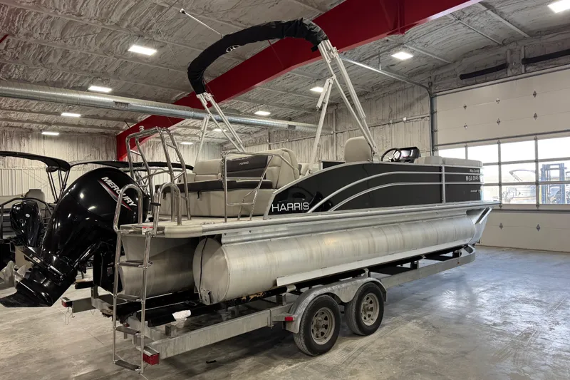 Slide: The Image of 2024 Harris Cruiser 230 pontoon boat in a garage, featuring a Mercury outboard motor. - 5