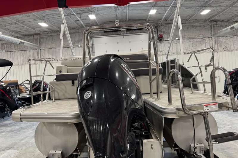 Slide: The Image of 2024 Harris Cruiser 230 pontoon boat with Mercury outboard motor in a showroom. - 6