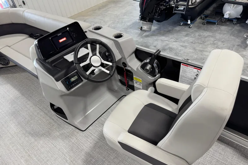 Slide: The Image of 2024 Harris Cruiser 230 boat interior with steering wheel, control panel, and comfortable seating. - 9
