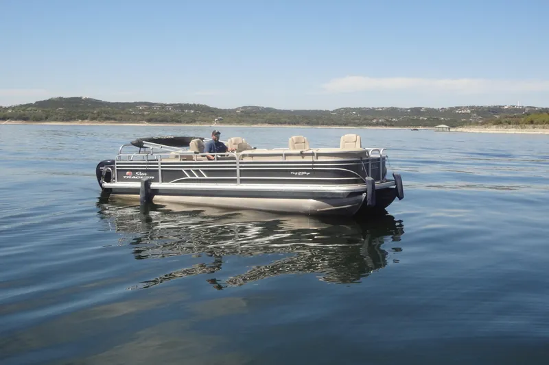 The Image of 2022 TRACKER MARINE Party Barge 24 DLX pontoon boat on a calm lake. - 1
