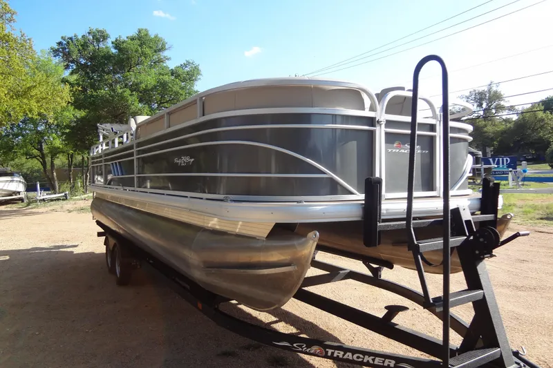 Slide: The Image of 2022 TRACKER MARINE Party Barge 24 DLX pontoon boat on trailer, outdoors. - 19
