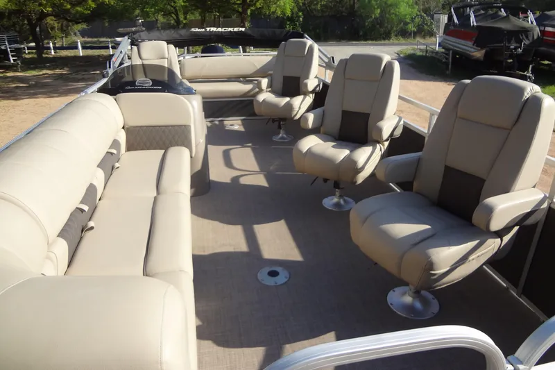 Slide: The Image of 2022 TRACKER MARINE Party Barge 24 DLX interior with beige seating and spacious layout. - 23