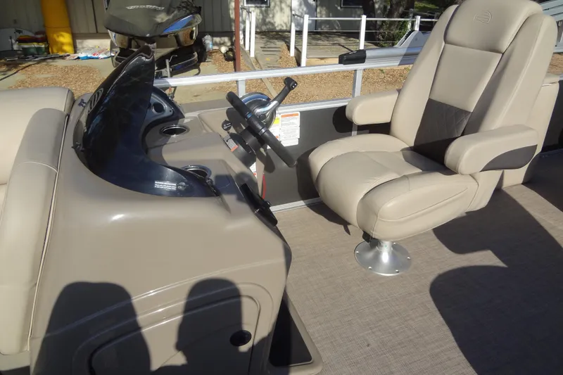 Slide: The Image of 2022 TRACKER MARINE Party Barge 24 DLX helm with beige captain's chair and steering wheel. - 29