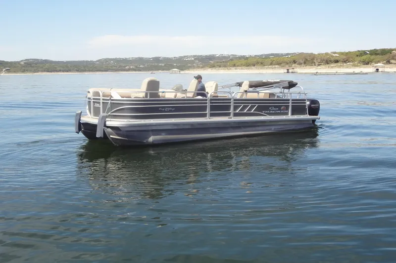 Slide: The Image of 2022 TRACKER MARINE Party Barge 24 DLX pontoon boat on a calm lake. - 3