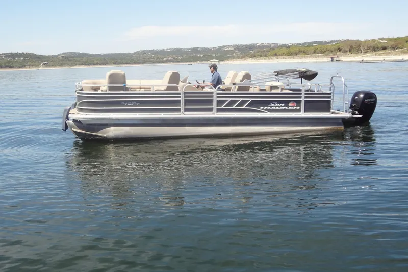 Slide: The Image of 2022 TRACKER MARINE Party Barge 24 DLX pontoon boat on a calm lake. - 4