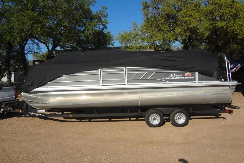 Slide: The Image of 2022 TRACKER MARINE Party Barge 24 DLX pontoon boat on trailer, covered, outdoors. - 48