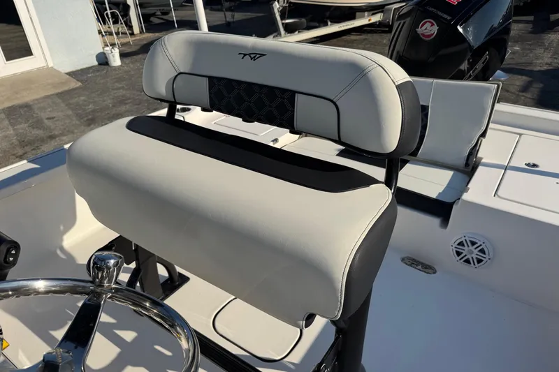 Slide: The Image of 2022 Tidewater 2410 Bay Max boat interior with steering wheel and cushioned seating. - 32