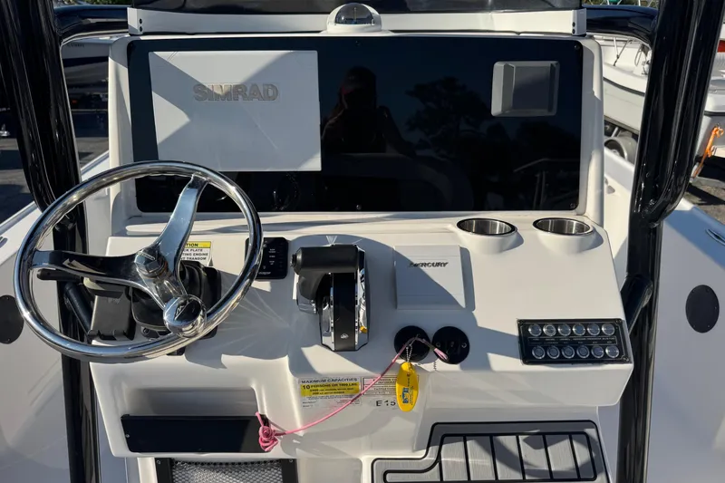 Slide: The Image of 2022 Tidewater 2410 Bay Max boat dashboard with steering wheel and Simrad display. - 4