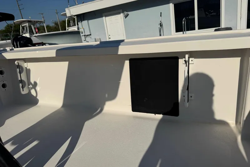 Slide: The Image of 2022 Tidewater 2410 Bay Max boat interior with storage compartment and shadows. - 46