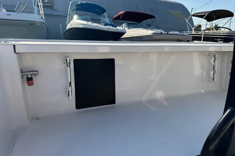 Slide: The Image of 2022 Tidewater 2410 Bay Max boat interior with storage compartment and clean white finish. - 47