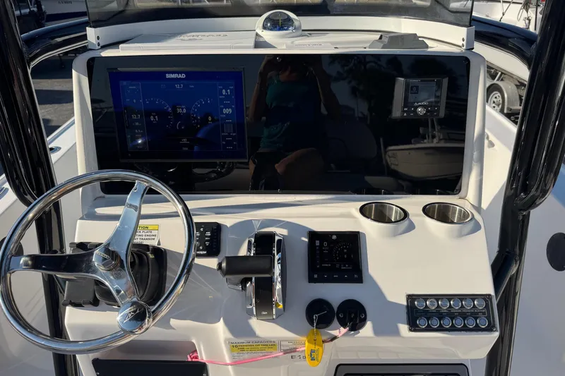 Slide: The Image of 2022 Tidewater 2410 Bay Max boat dashboard with steering wheel and electronic controls. - 8