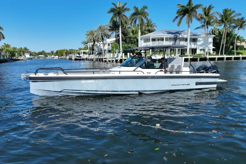 The Image of 2021 Axopar 28 T-Top boat cruising on a sunny waterway with palm trees. - 0