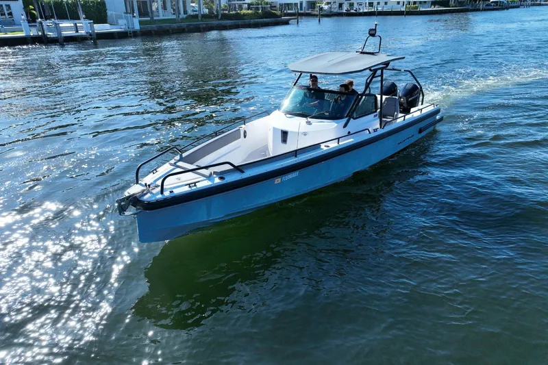 Slide: The Image of 2021 Axopar 28 T-Top boat cruising on a sunny waterway. - 10