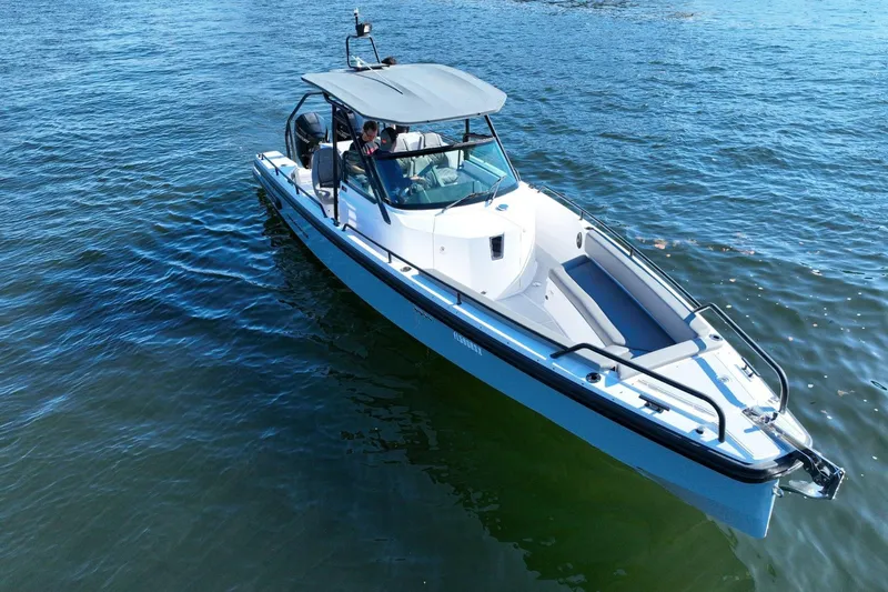 Slide: The Image of 2021 Axopar 28 T-Top boat cruising on calm blue waters. - 2