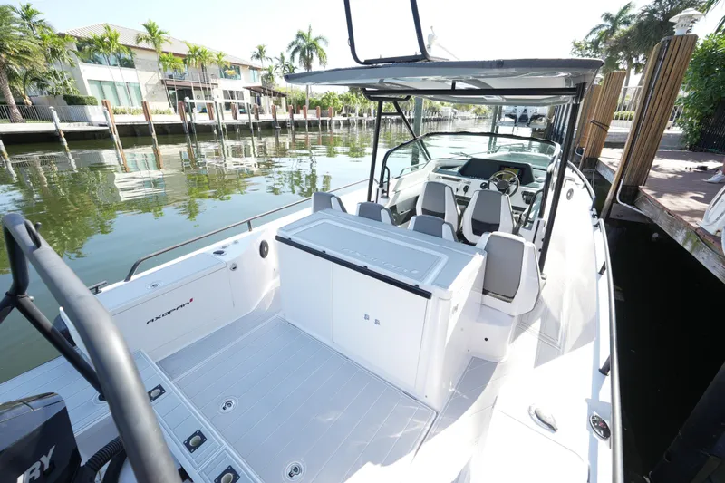 Slide: The Image of 2021 Axopar 28 T-Top boat docked by waterfront homes, showcasing sleek design. - 20