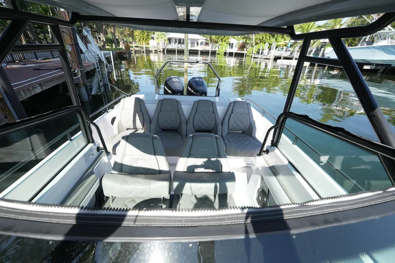 Slide: The Image of 2021 Axopar 28 T-Top boat interior with seating, docked by a serene waterfront. - 22