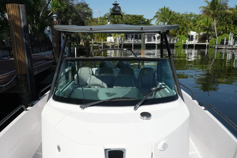 Slide: The Image of 2021 Axopar 28 T-Top boat docked by lush waterfront. - 24