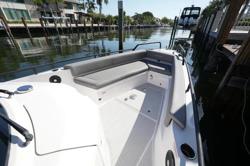 Slide: The Image of 2021 Axopar 28 T-Top boat with spacious seating, docked by waterfront homes. - 26