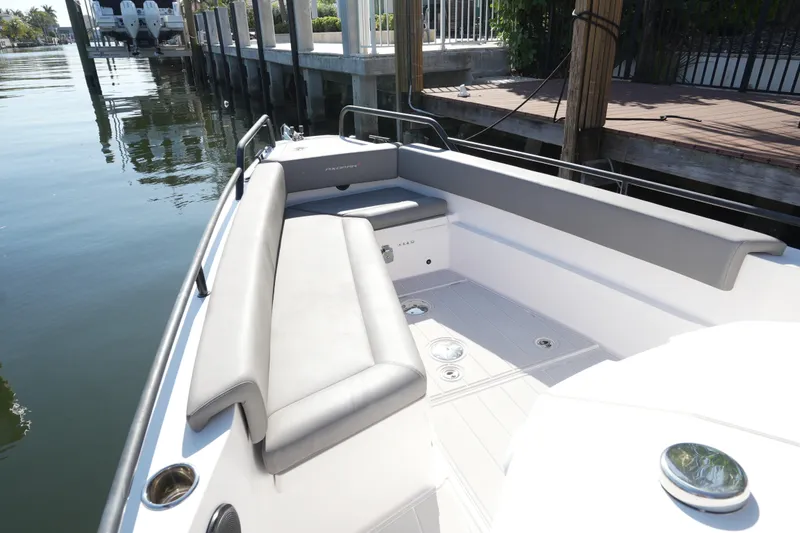 Slide: The Image of 2021 Axopar 28 T-Top boat with sleek seating and modern design at a dock. - 28
