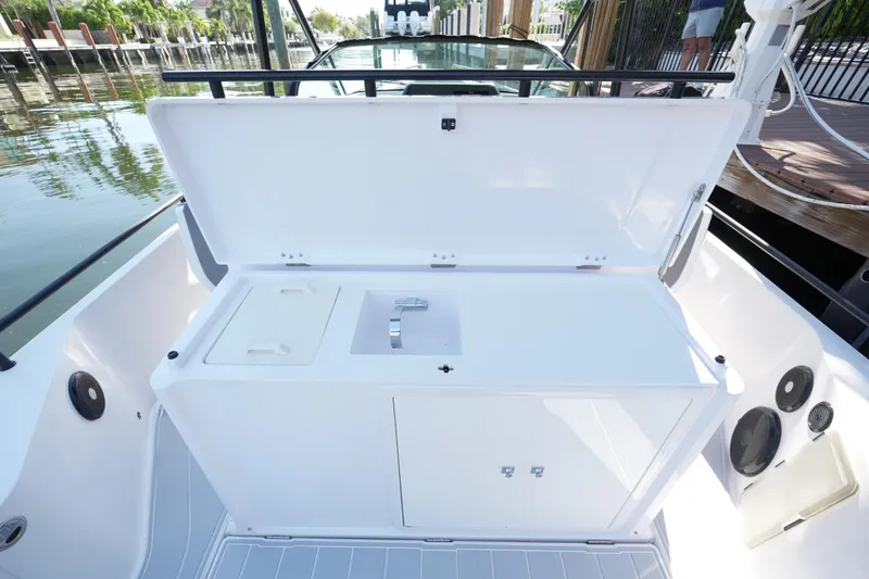 Slide: The Image of 2021 Axopar 28 T-Top boat with open storage compartment and sink on deck. - 29