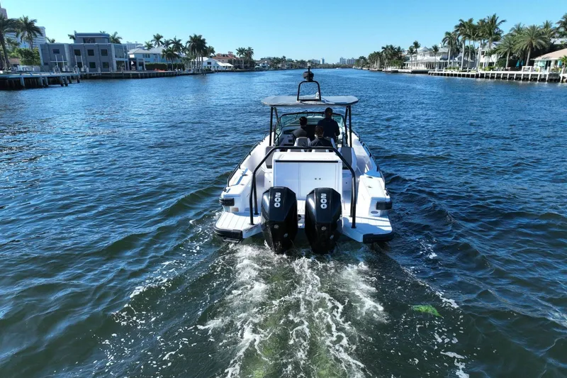 Slide: The Image of 2021 Axopar 28 T-Top cruising on a scenic waterway with palm trees. - 3
