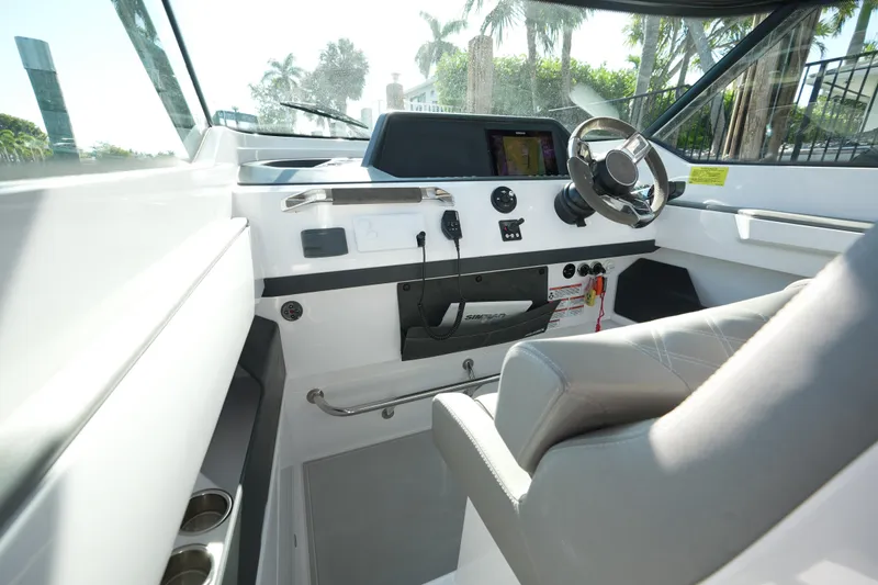Slide: The Image of 2021 Axopar 28 T-Top boat interior with steering wheel and dashboard controls. - 32