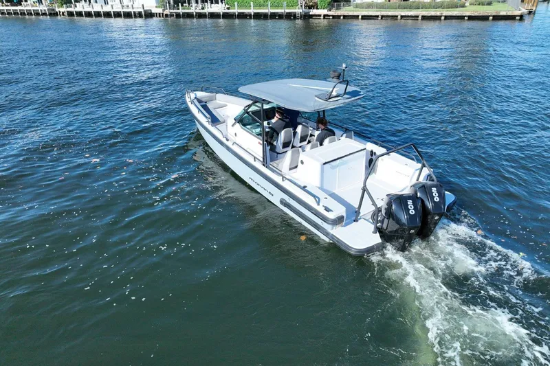 Slide: The Image of 2021 Axopar 28 T-Top boat cruising on a sunny day with dual engines. - 4