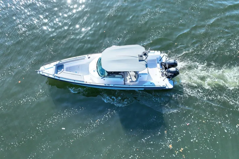 Slide: The Image of Aerial view of 2021 Axopar 28 T-Top boat cruising on water. - 5
