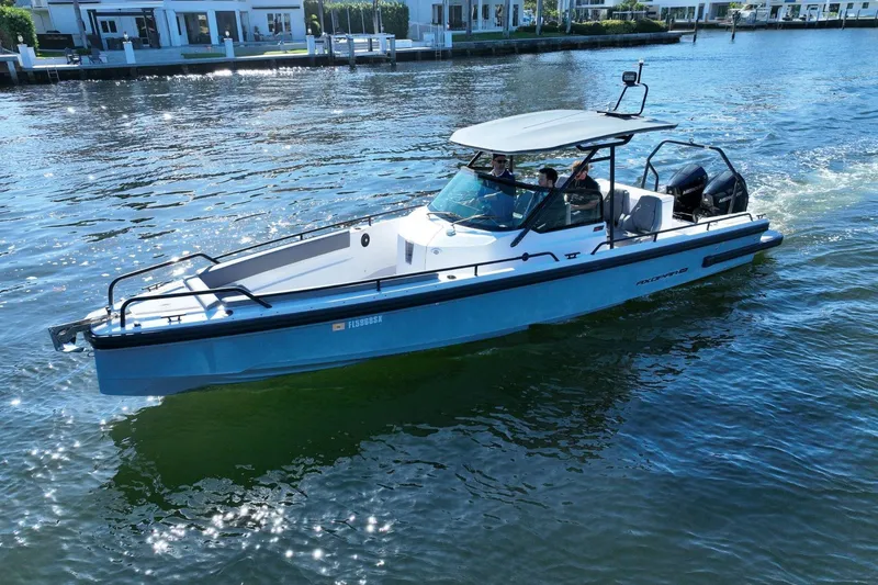 Slide: The Image of 2021 Axopar 28 T-Top boat cruising on a sunny waterfront. - 8