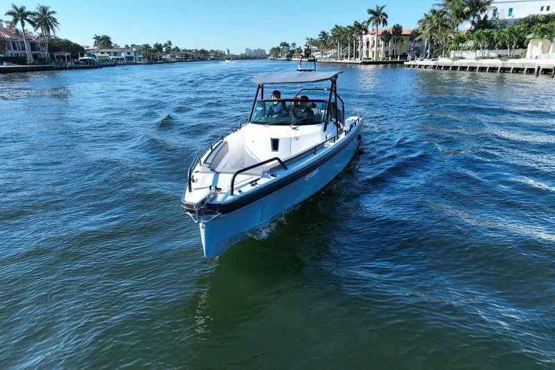 Slide: The Image of 2021 Axopar 28 T-Top boat cruising on a scenic waterway with palm trees. - 9