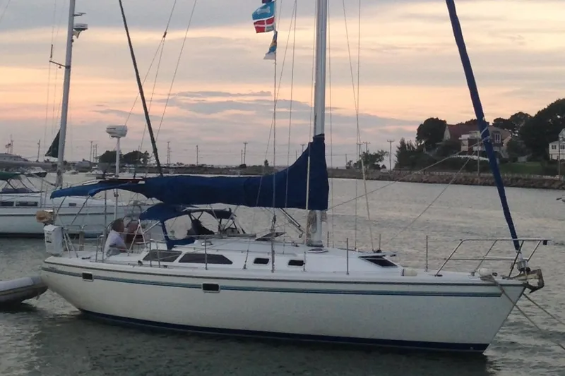 The Image of 1998 Catalina 36 MkII sailboat docked at sunset with calm waters and scenic background. - 0