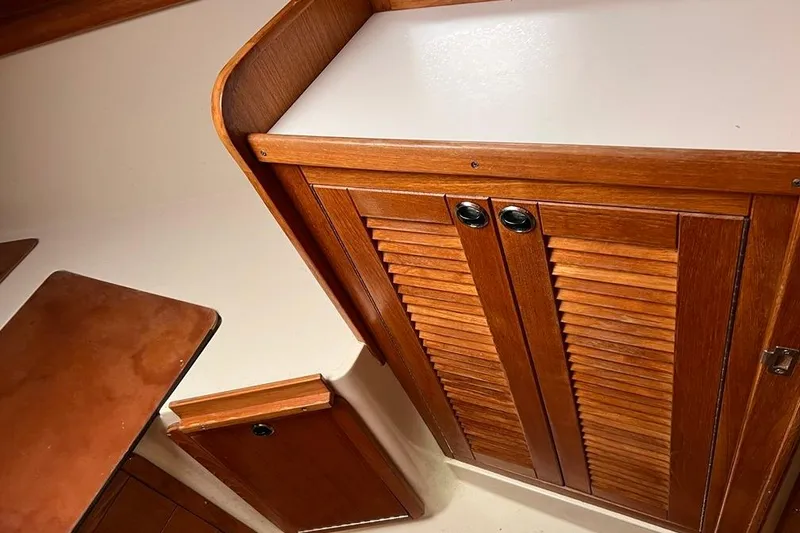 Slide: The Image of Wooden cabinetry inside a 1998 Catalina 36 MkII sailboat, featuring louvered doors. - 37